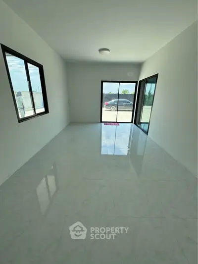 Spacious empty room with large windows and glossy tiled floor, perfect for customization.
