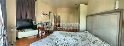 Spacious bedroom with modern decor and ample natural light, featuring a cozy bed and stylish furnishings.