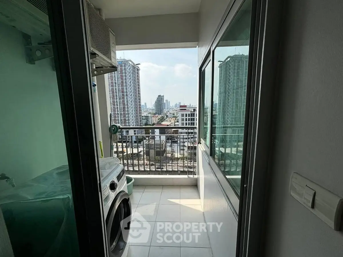 Modern balcony with city view and laundry area in high-rise apartment