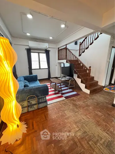 Charming living room with wooden staircase and stylish lighting in cozy home