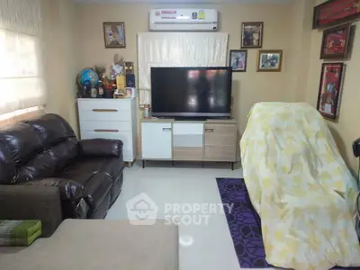 Cozy living room with modern furniture and large TV, perfect for relaxation.