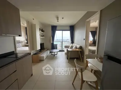 Modern open-plan living room with city view, stylish furniture, and natural light.
