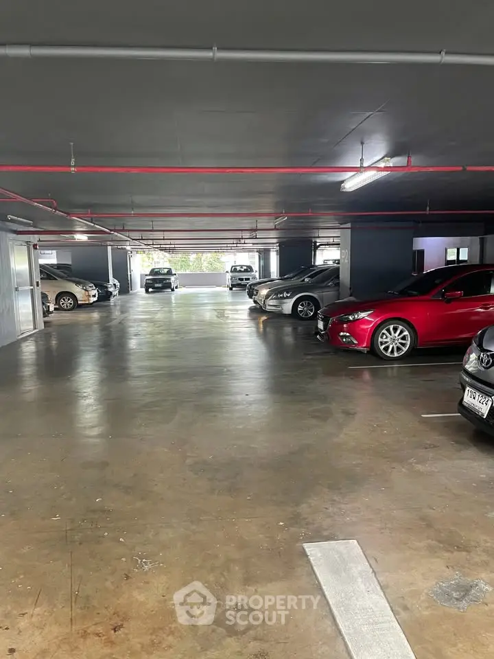 Spacious indoor parking area with multiple cars in a modern building.