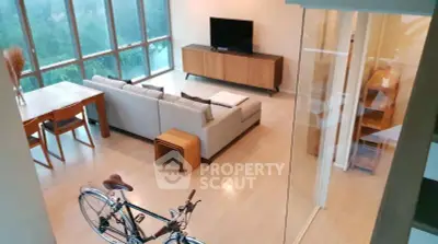 Spacious modern living room with large windows and stylish furniture, perfect for relaxation.