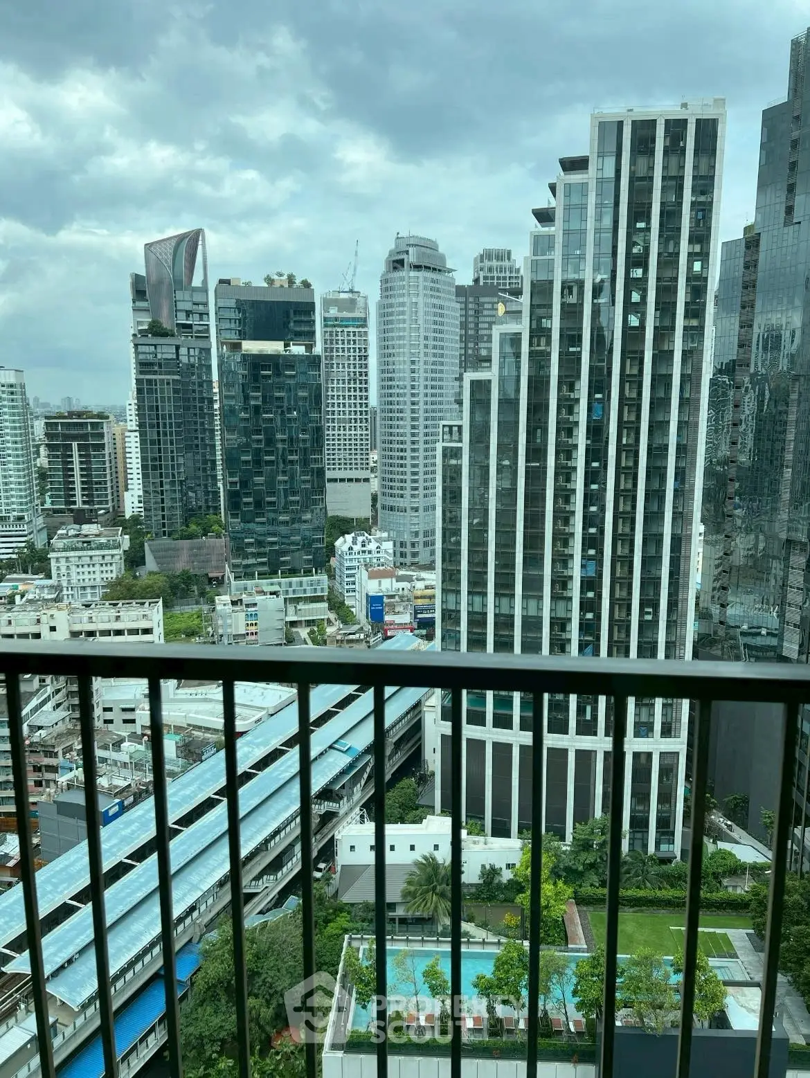 Stunning urban cityscape view from high-rise balcony overlooking modern skyscrapers.