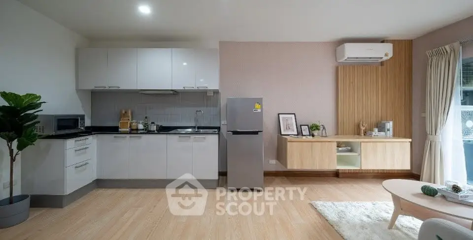 Modern open-layout kitchen and living room with sleek design and natural light.