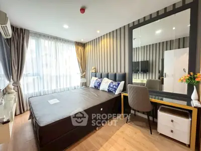 Modern bedroom with stylish decor and large window for natural light.