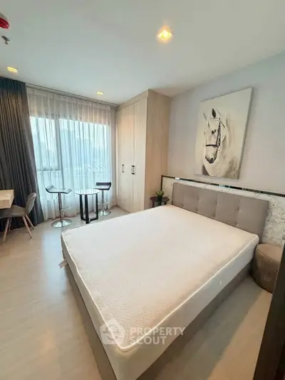 Modern bedroom with stylish decor and large window for natural light