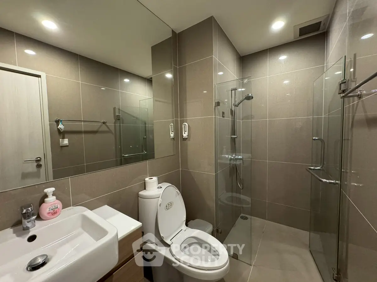 Modern bathroom with sleek design, glass shower, and elegant fixtures in a contemporary apartment.