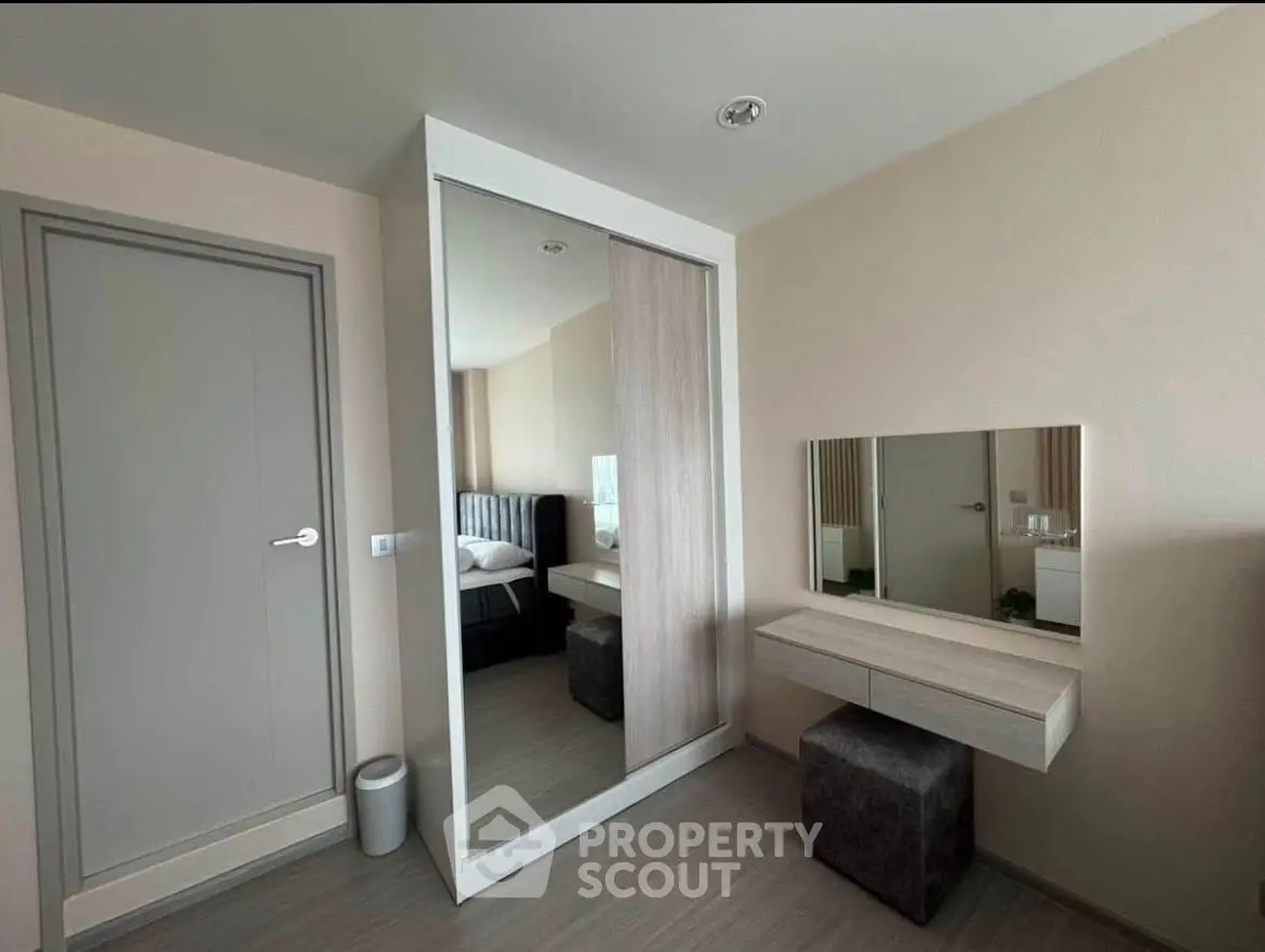 Modern bedroom with sleek wardrobe and stylish vanity in a contemporary apartment.