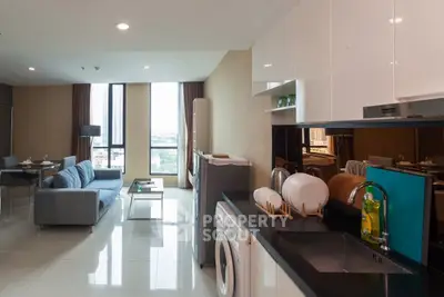 Modern open-plan living room and kitchen with city view, sleek furniture, and natural light.