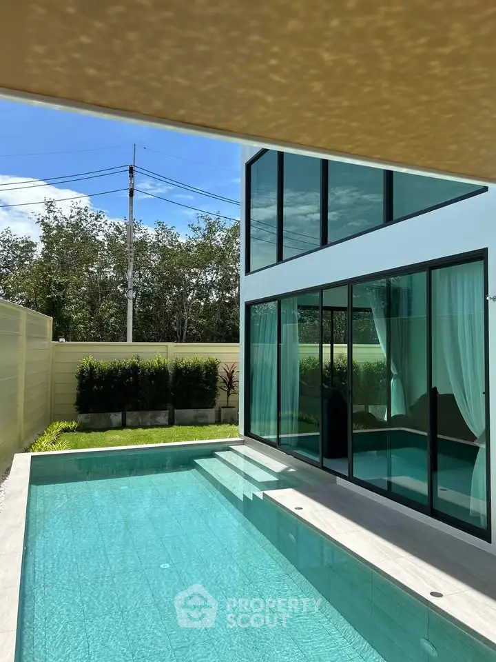 Luxurious modern home with private pool and glass facade, perfect for relaxation and entertainment.