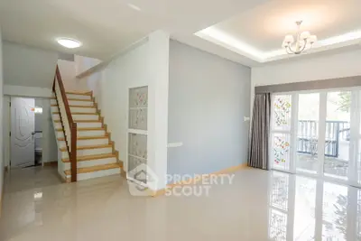 Spacious modern living room with elegant staircase and large windows