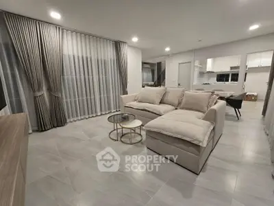 Spacious modern living room with elegant curtains and cozy sectional sofa in open layout design.