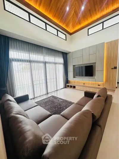 Luxurious living room with modern design, high ceiling, and elegant lighting.