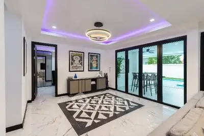Modern living room with stylish lighting and large glass doors leading to a patio.