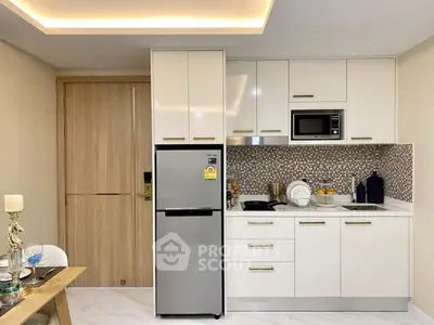 Modern kitchen with sleek white cabinets, stainless steel appliances, and stylish backsplash.