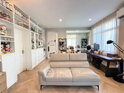 Stylish living room with modern sofa and extensive shelving, perfect for collectors.