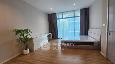 Spacious modern bedroom with large window and elegant decor