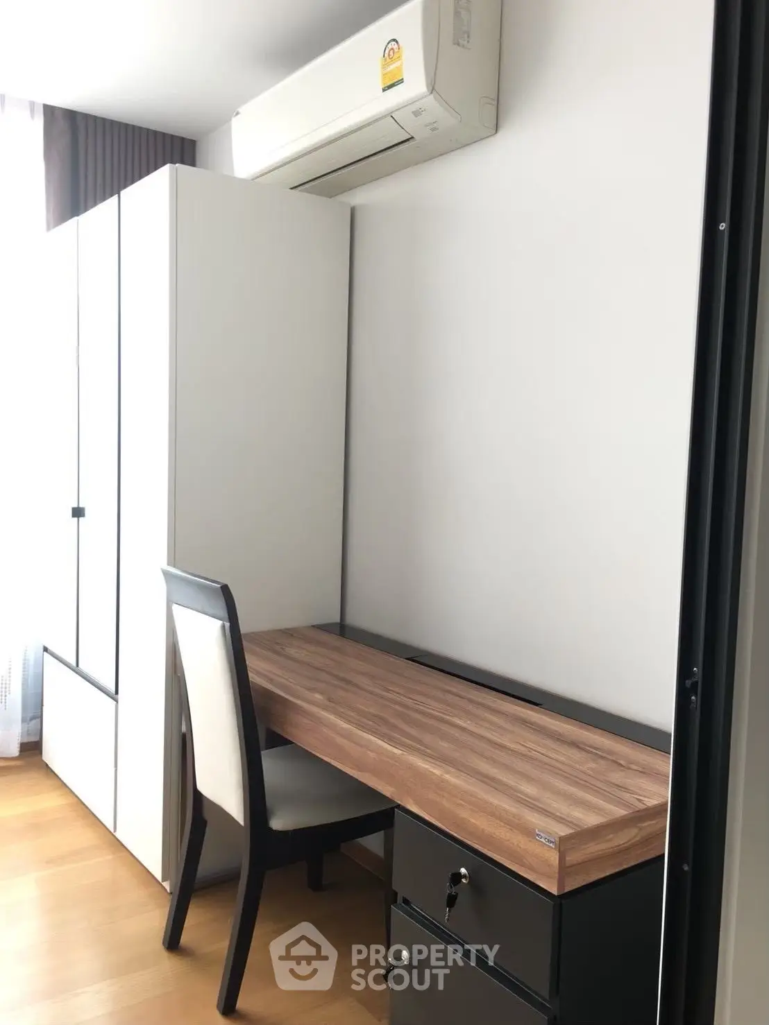 Modern study area with sleek desk and chair in a bright room with air conditioning.