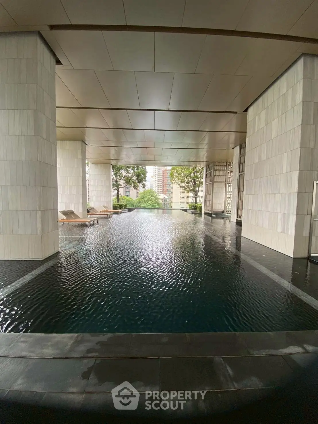 Luxurious indoor pool with stunning city view in modern high-rise building.