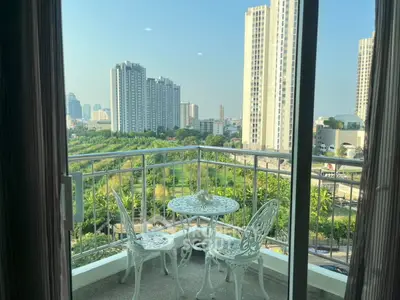 Charming balcony with elegant furniture offering stunning cityscape views in a high-rise apartment.