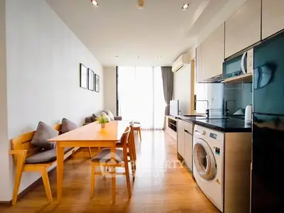 Modern open-plan kitchen and living area with wooden flooring and natural light.