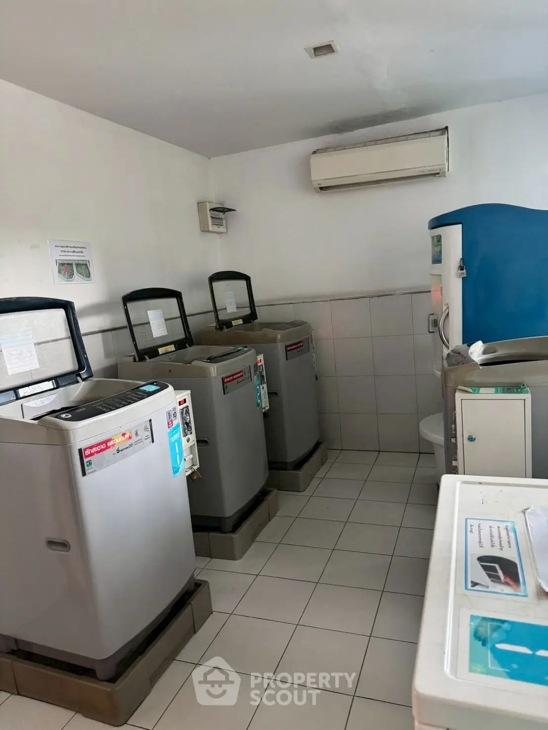 Modern laundry room with multiple washing machines and air conditioning