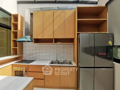 Modern kitchen with sleek cabinetry and stainless steel appliances in a bright, sunlit space.