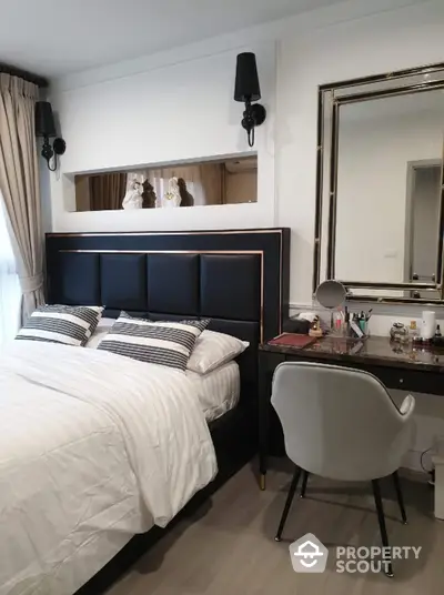 Elegant bedroom with modern decor, featuring a stylish bed, chic vanity, and sophisticated lighting.