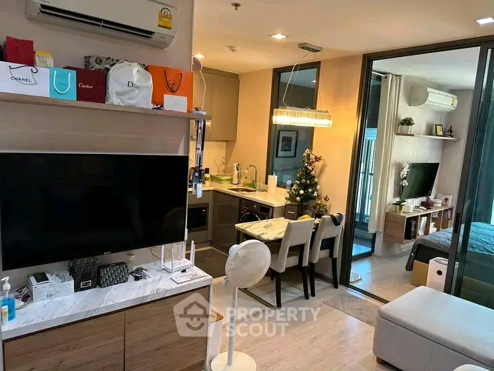 Modern living room with open kitchen and stylish decor, featuring a cozy bedroom view.