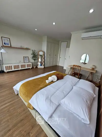 Spacious bedroom with modern decor and wooden flooring