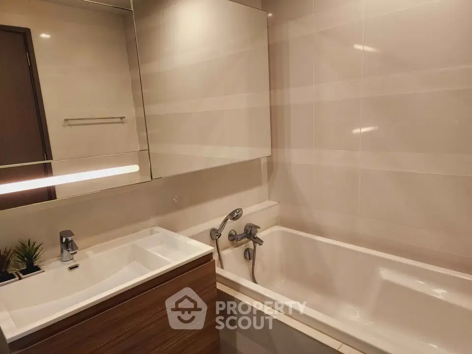 Modern bathroom with sleek fixtures and a bathtub in a contemporary apartment.