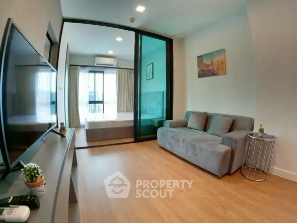 Modern living room with sleek design and cozy ambiance, featuring a large TV and comfortable sofa.