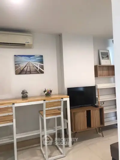 Modern living room with stylish furniture and wall art, featuring a sleek TV stand and air conditioning.