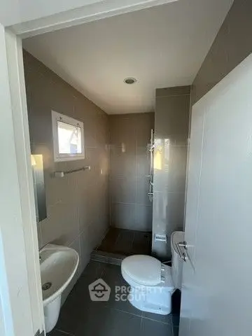 Compact modern bathroom with sleek fixtures and neutral tiles