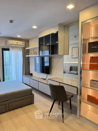 Modern bedroom with sleek furniture and stylish decor, featuring a wall-mounted TV and elegant shelving.