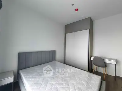 Modern minimalist bedroom with sleek furniture and ample natural light.