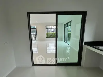Modern open-plan living space with sliding glass doors and sleek tile flooring