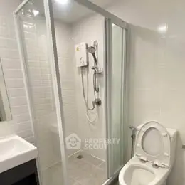 Modern bathroom with glass shower enclosure and sleek fixtures