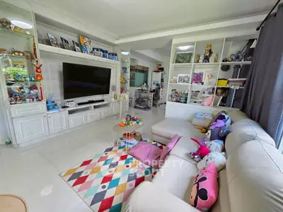 Spacious living room with modern decor and entertainment center, perfect for family gatherings.