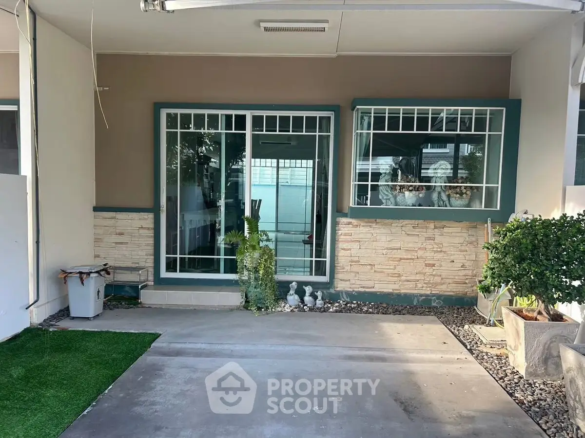 Charming home entrance with large windows and decorative stone facade