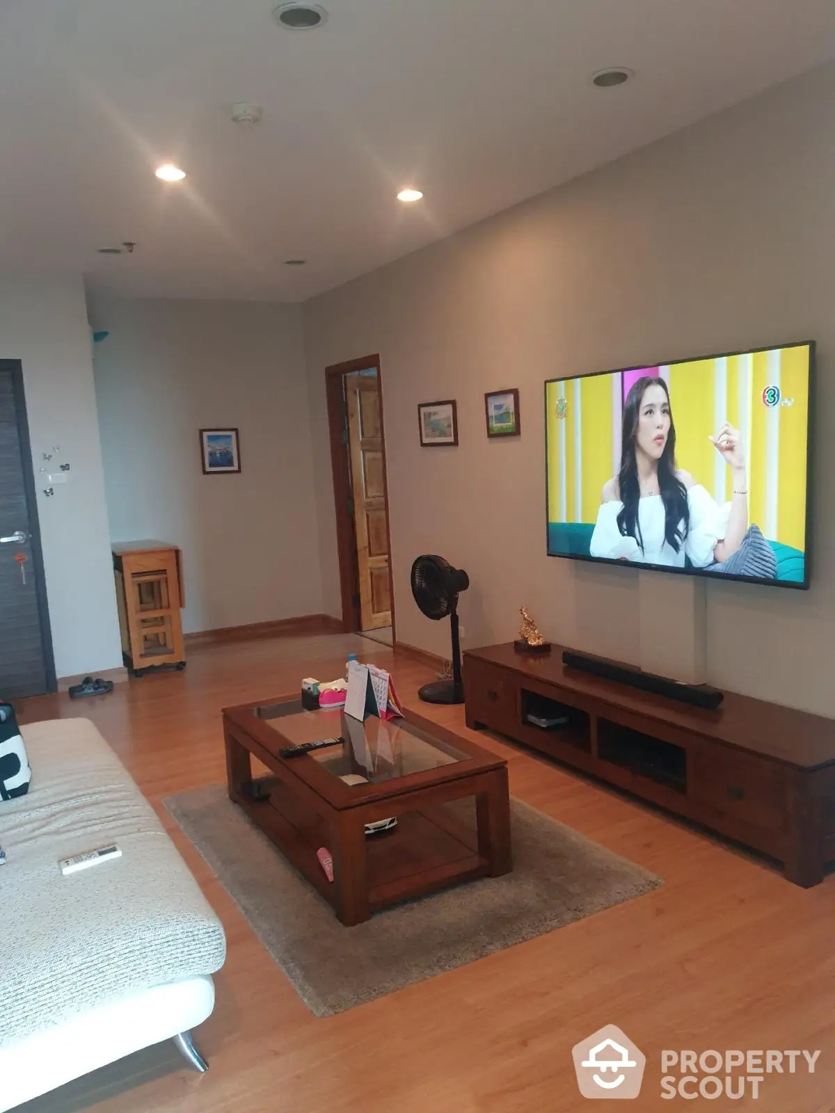 Spacious living room with modern decor and wall-mounted TV