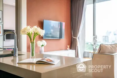 Modern living room with elegant decor and city view, featuring a sleek kitchen island.