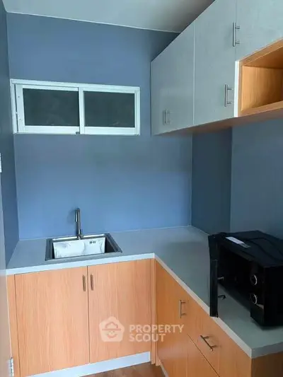 Modern kitchen with sleek cabinetry and compact design, featuring a stylish sink and ample storage space.