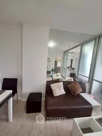Modern living room with sleek furniture and glass partition in a stylish apartment.
