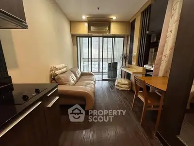 Cozy living room with modern furniture and balcony view in urban apartment.