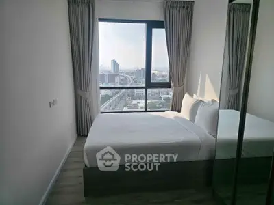 Modern bedroom with city view, featuring large window and sleek design, perfect for urban living.