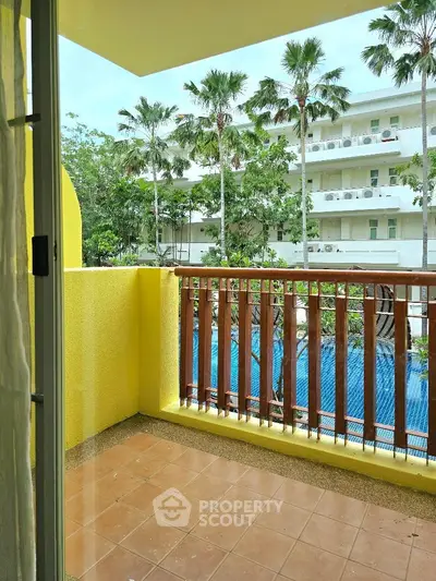 Charming balcony with pool view in tropical setting, perfect for relaxation.