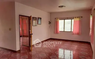 Spacious empty room with pink tiled floor and large windows, perfect for customization.